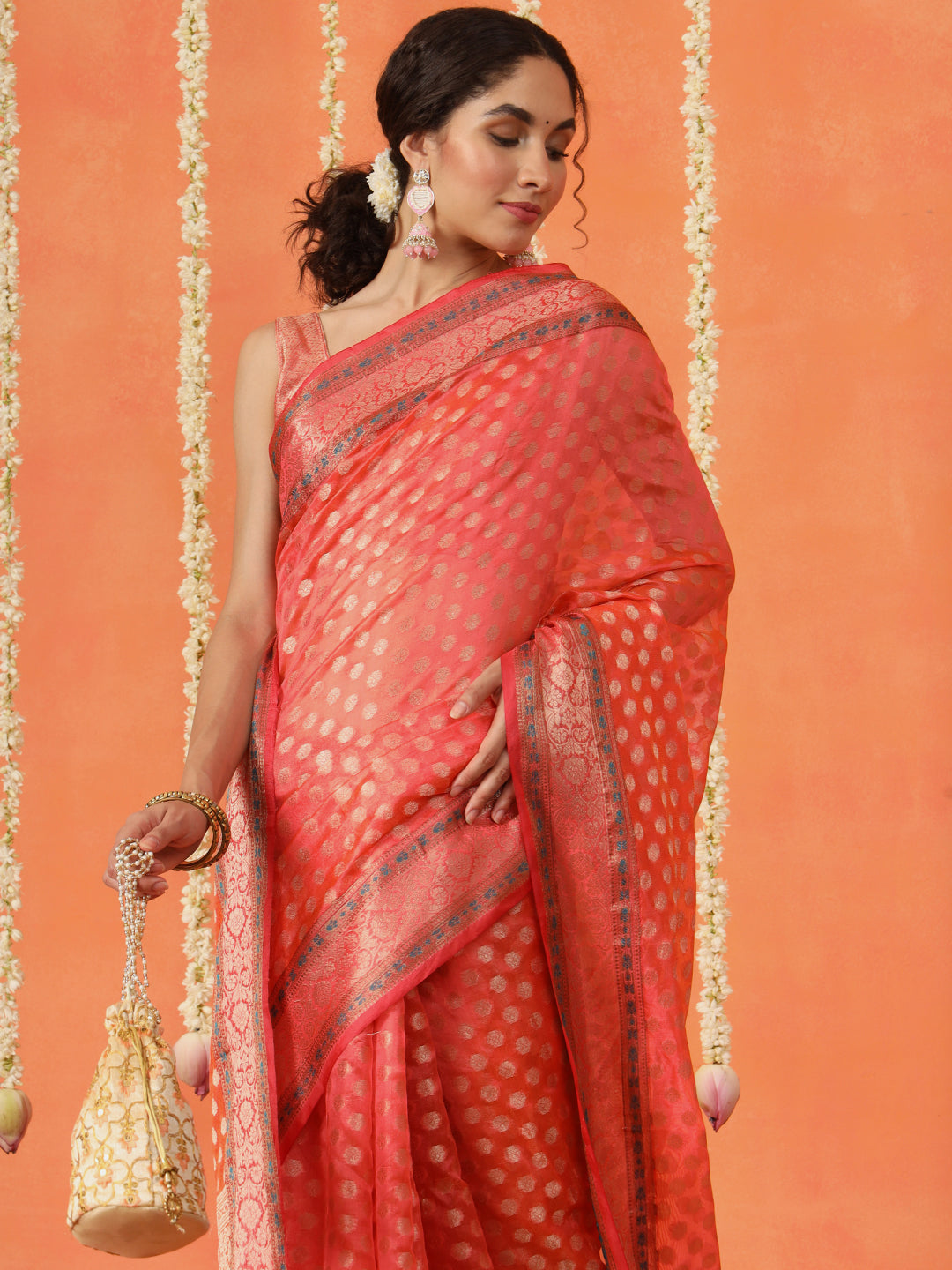 Peach colored art silk woven designer saree with tassles on pallu