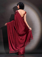 Maroon colored satin saree with sequin embroidery on shoulder portion and tassles on pallu