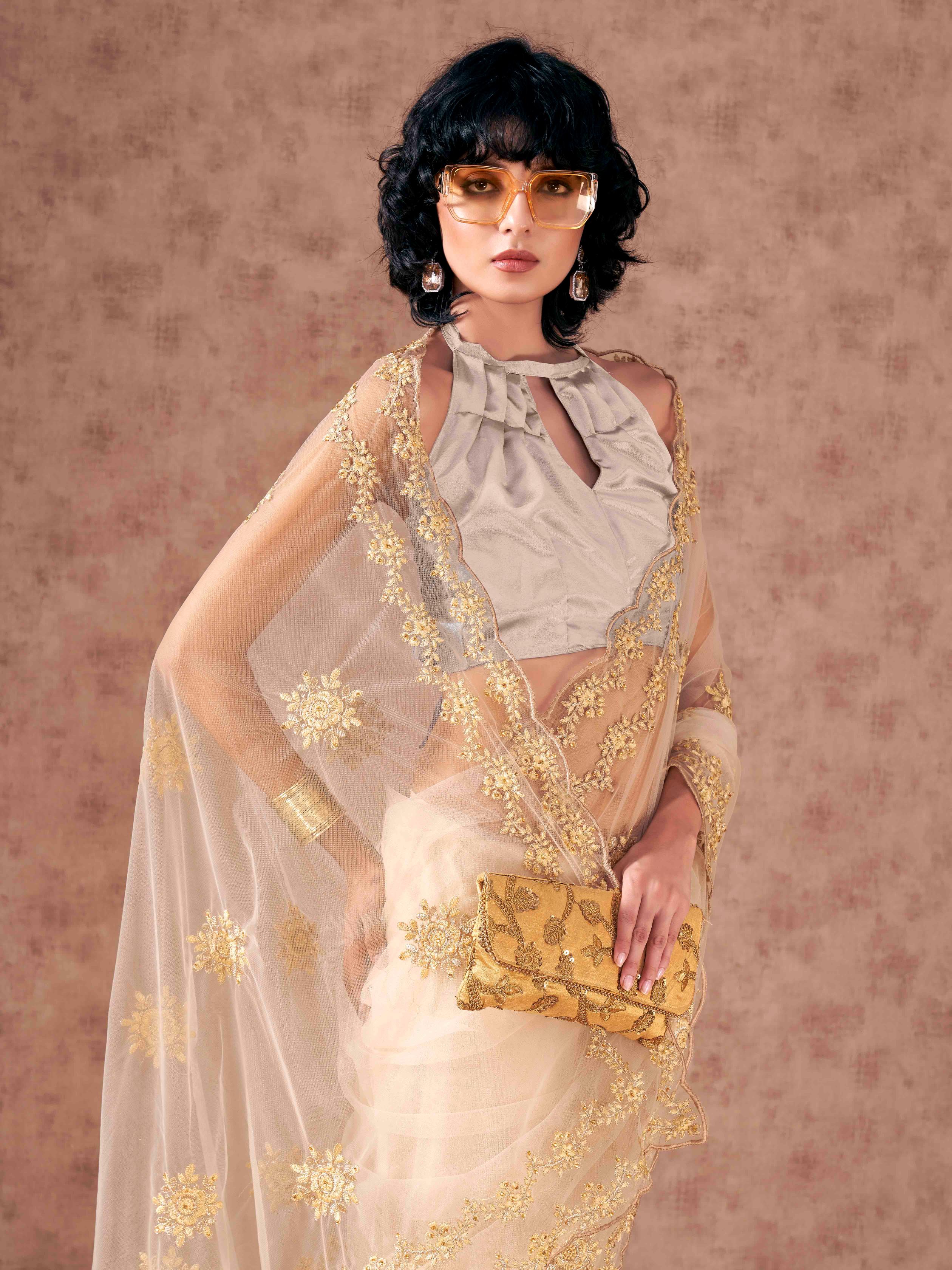 Cream colored net saree with thread work scalloped border and faux diamonds