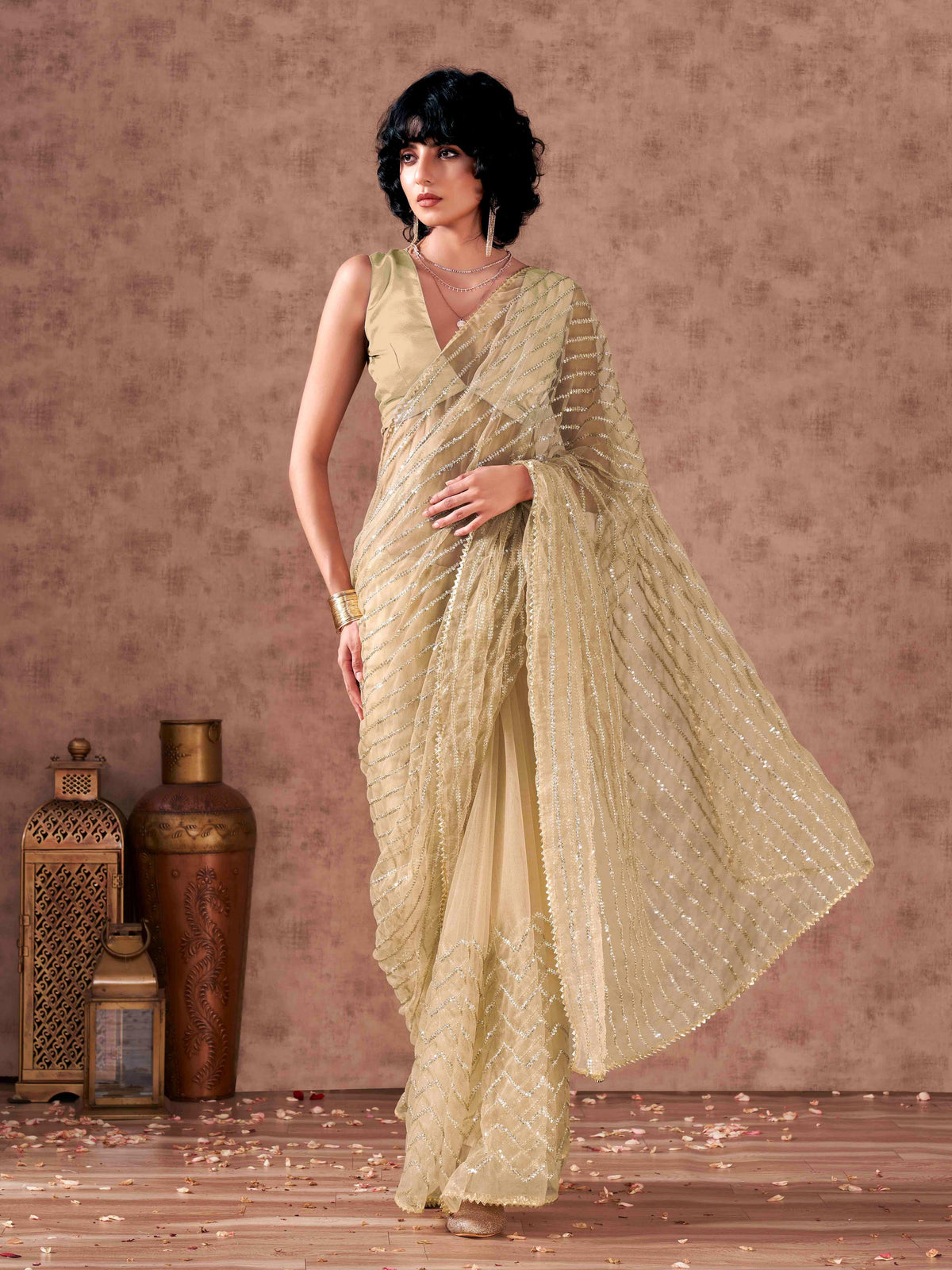 Beige colored sequinned embroidered net saree with embellished border