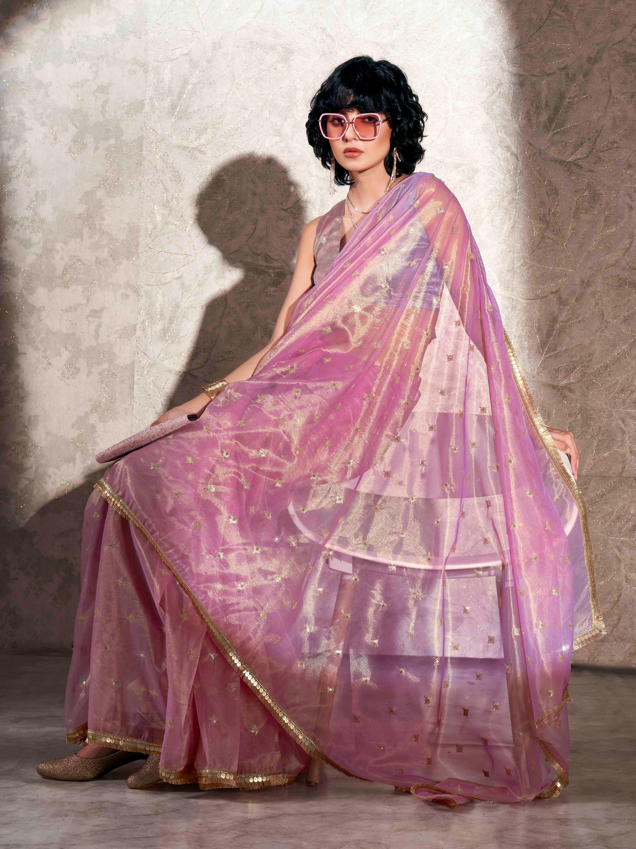 Pink colored shimmer net saree with sequence embroidery and sequinned tassle lace