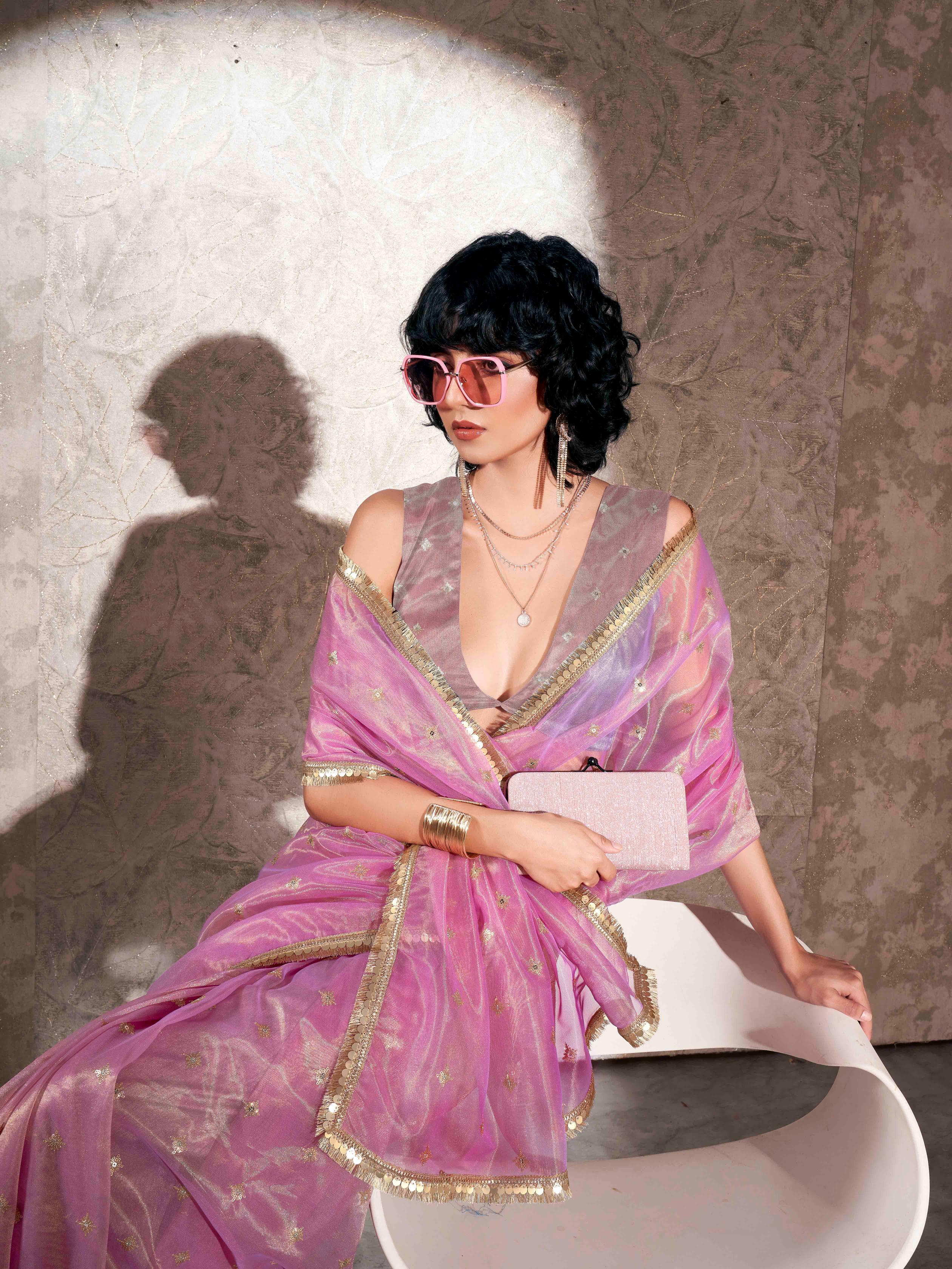 Pink colored shimmer net saree with sequence embroidery and sequinned tassle lace