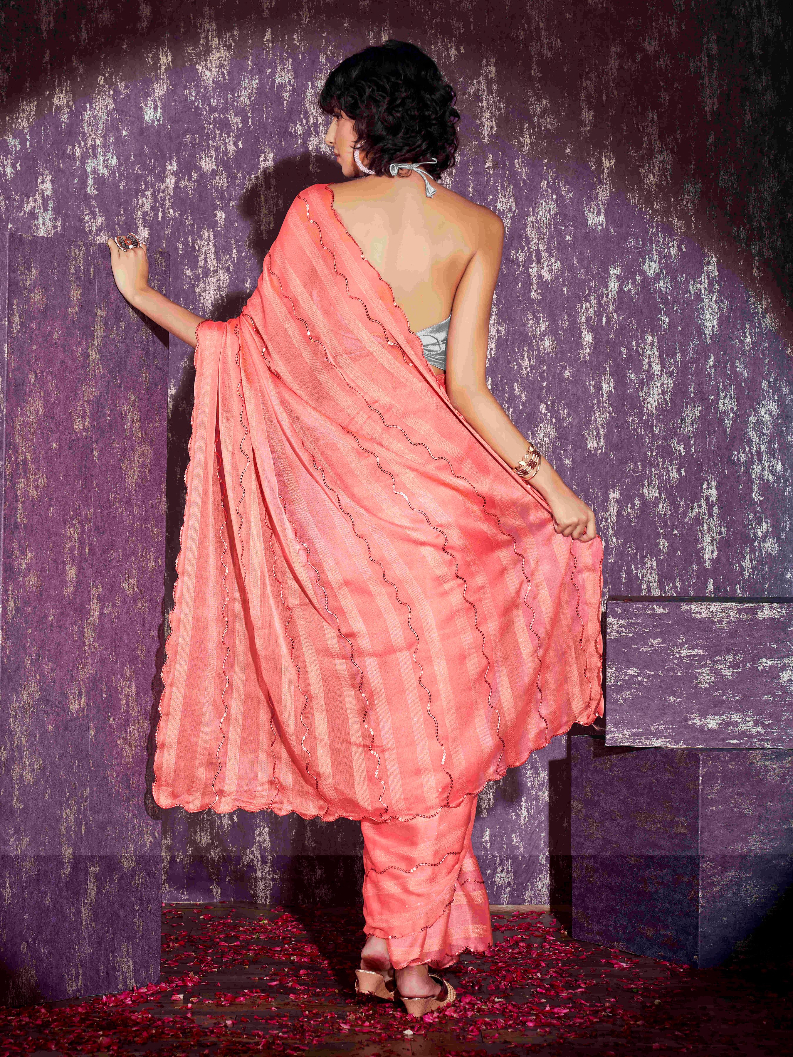 Peach colored satin striped saree with sequence embroidery and scalloped border