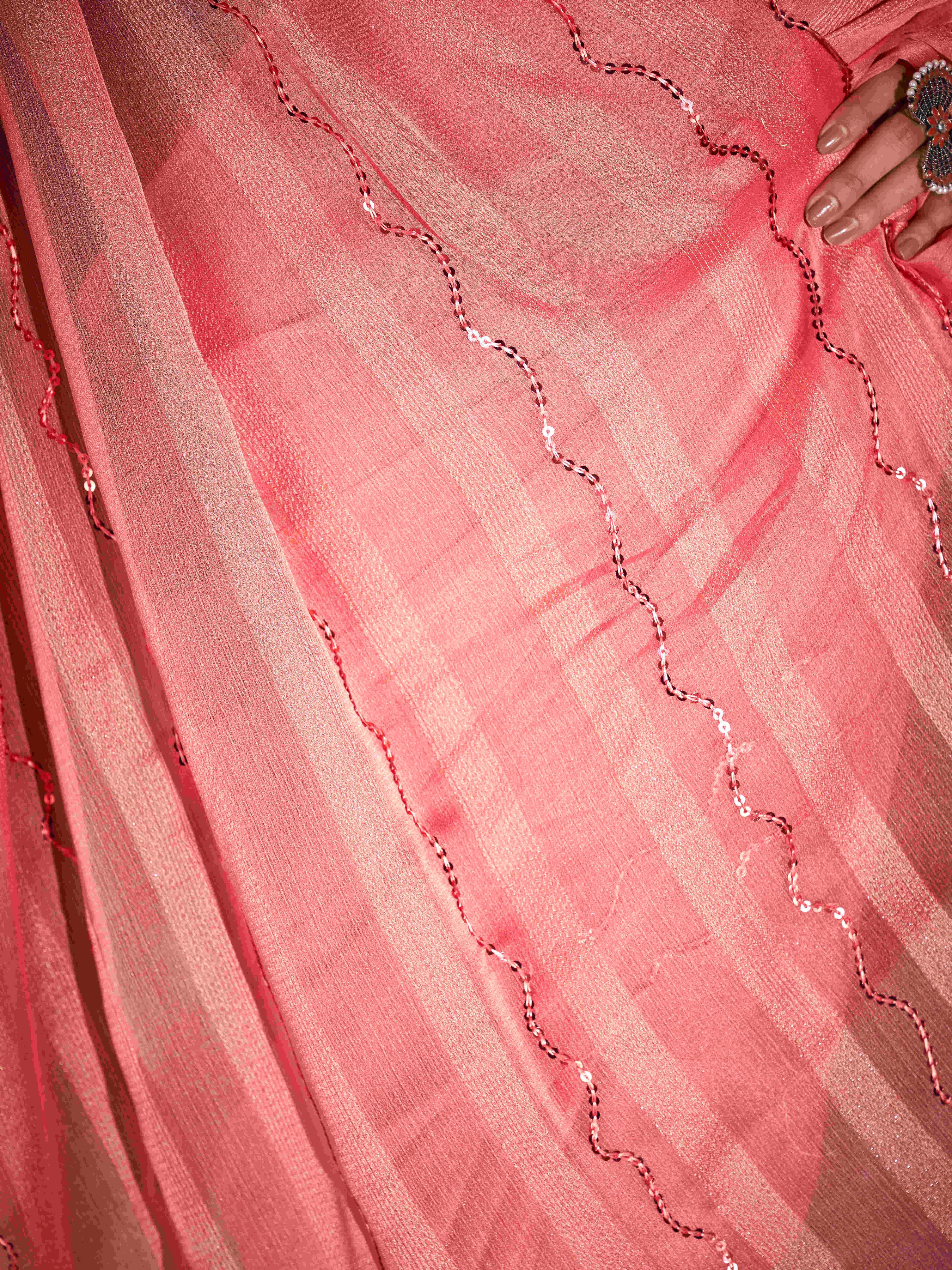 Peach colored satin striped saree with sequence embroidery and scalloped border