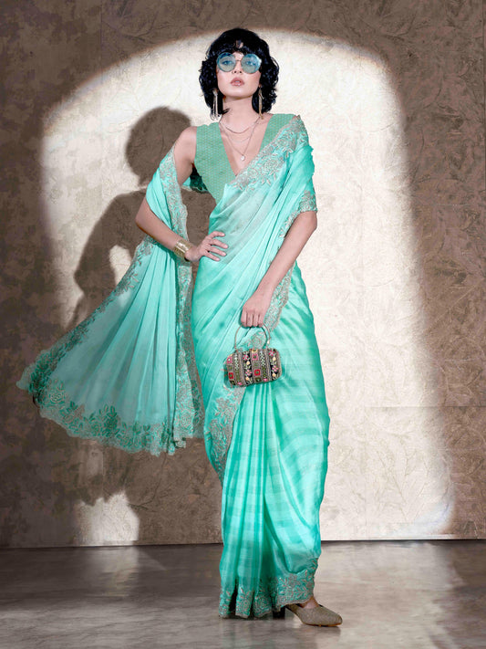 Sea green colored striped embroidered saree with brocade blouse