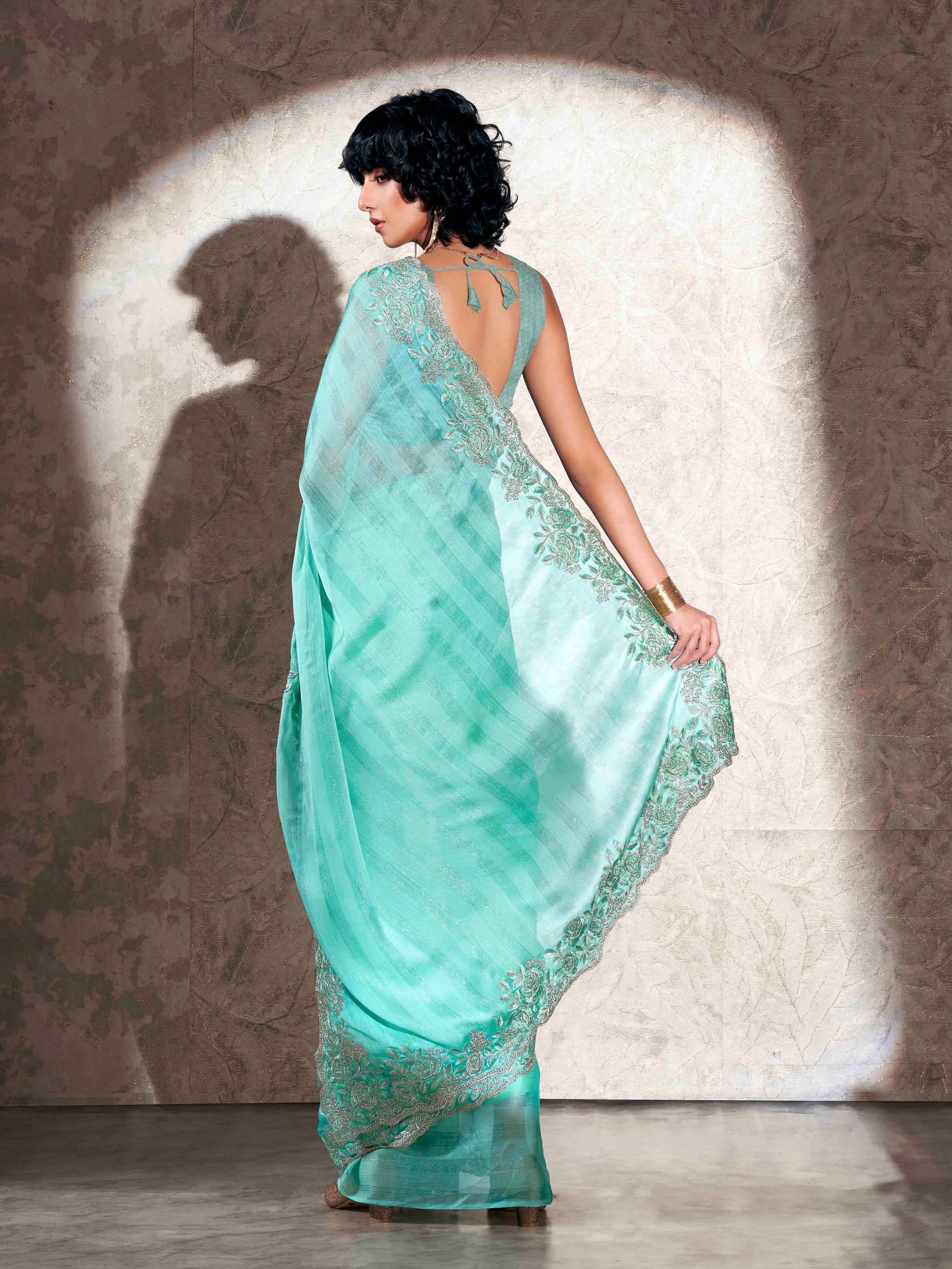 Sea green colored striped embroidered saree with brocade blouse