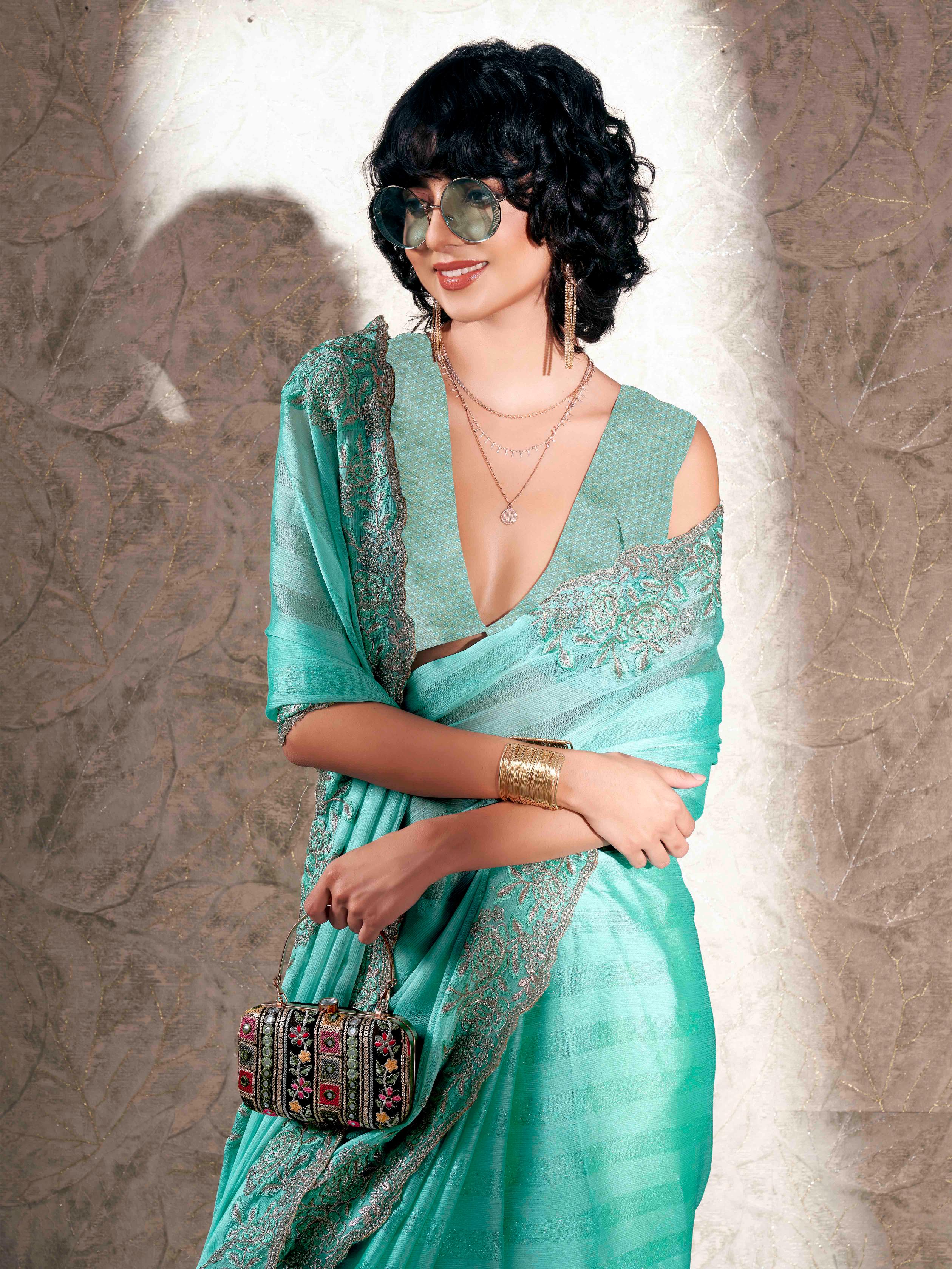 Sea green colored striped embroidered saree with brocade blouse