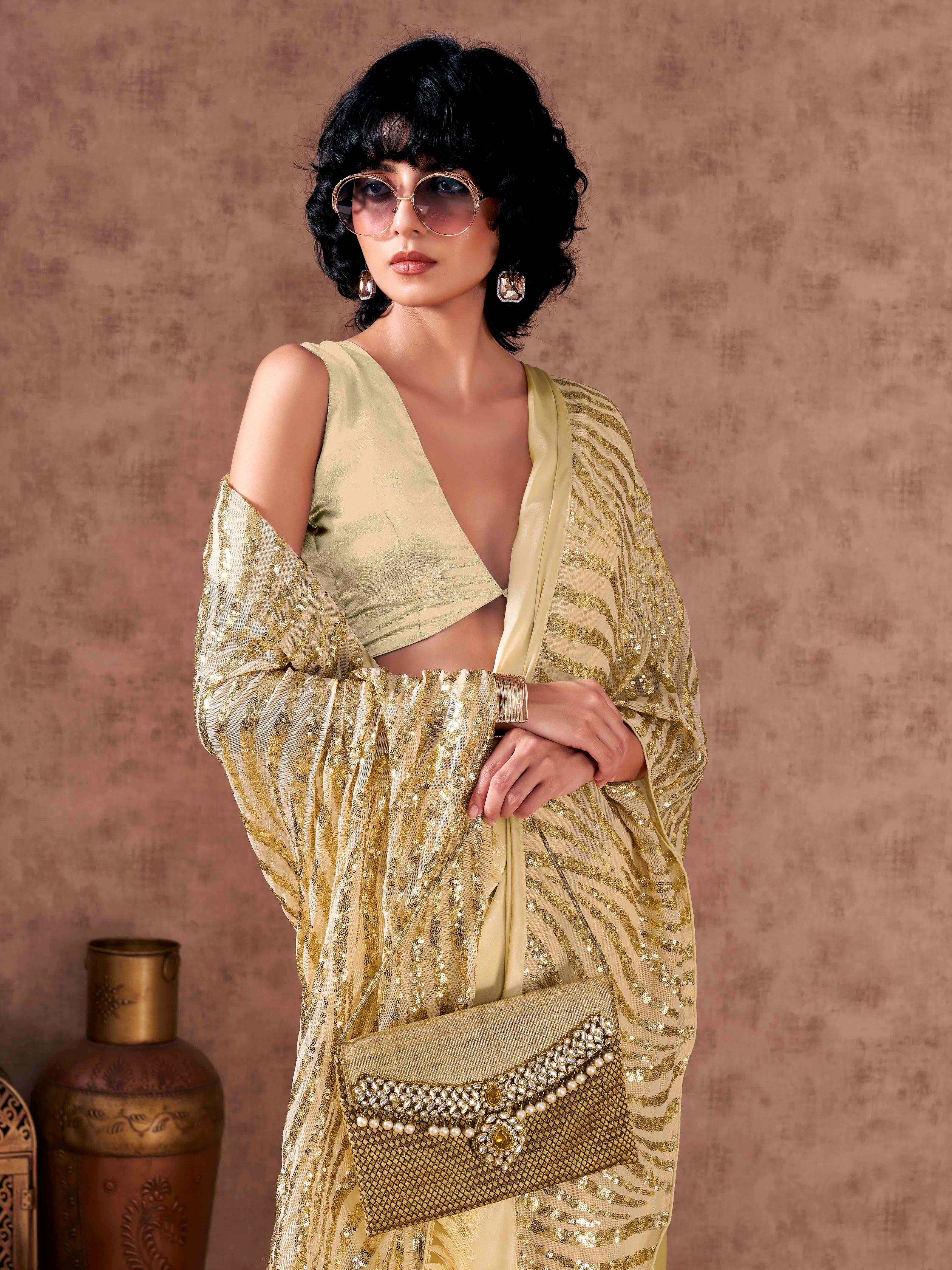 Beige colored designer sequence embroidered satin saree with tassles on pallu