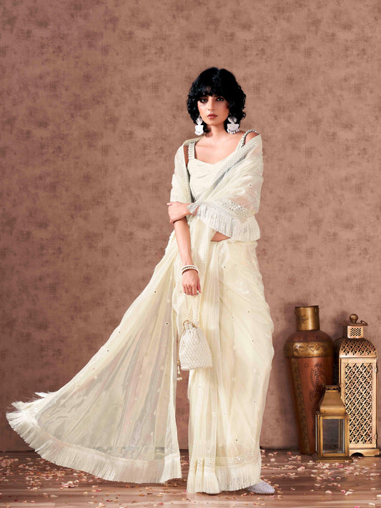 Off white colored supernet saree with faux mirror embroidery and tassles lace