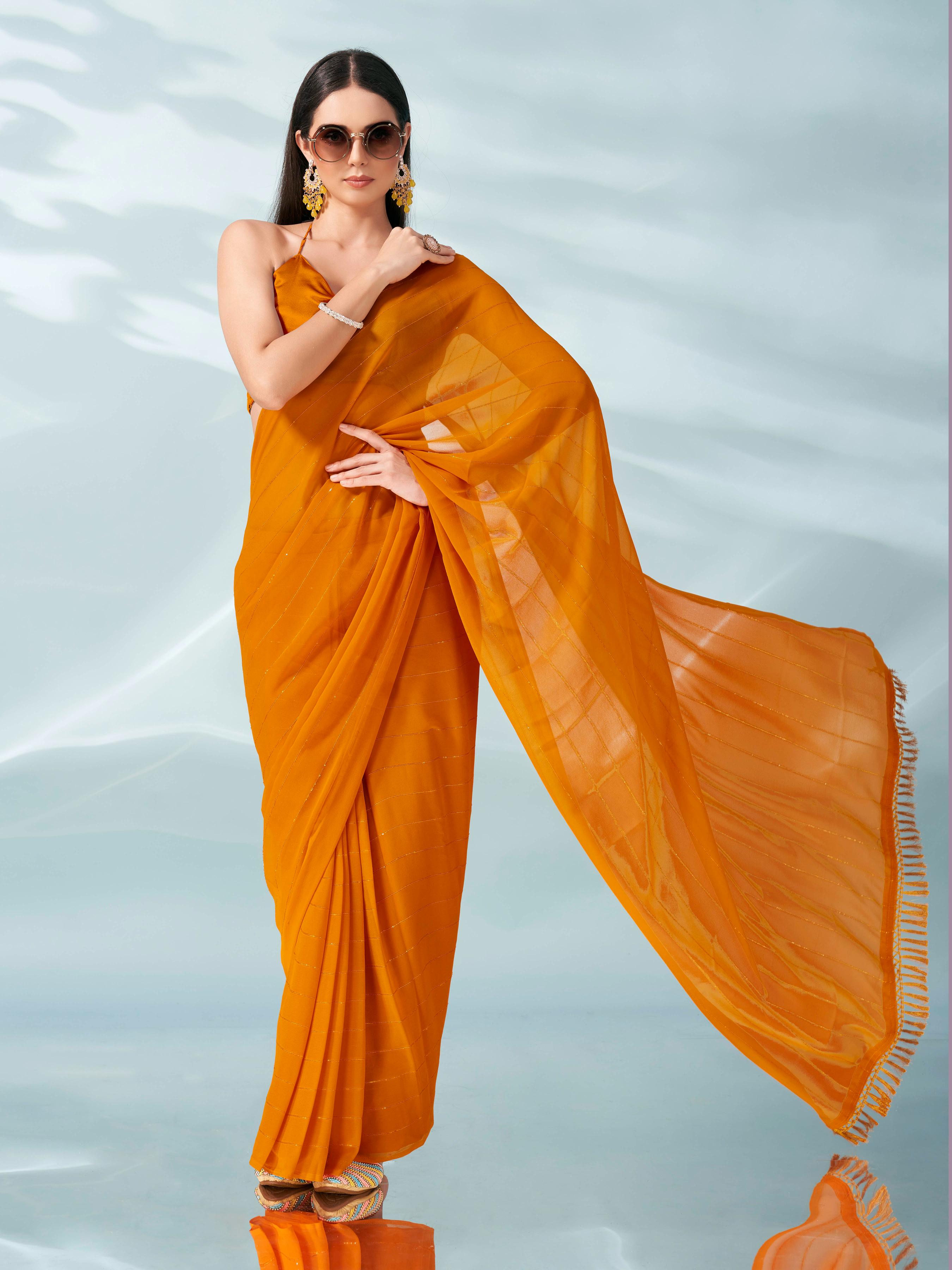 Yellow colored sequinned georgette saree with brocade blouse