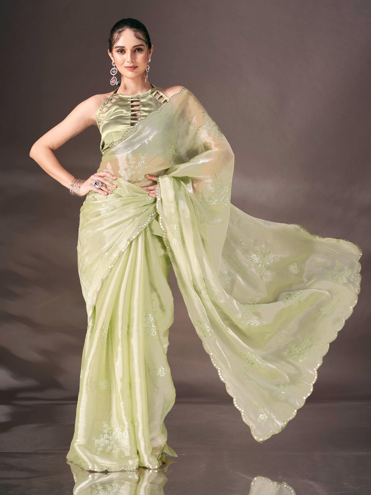 Pista green colored shimmer satin saree with sequence embroidery and scalloped border