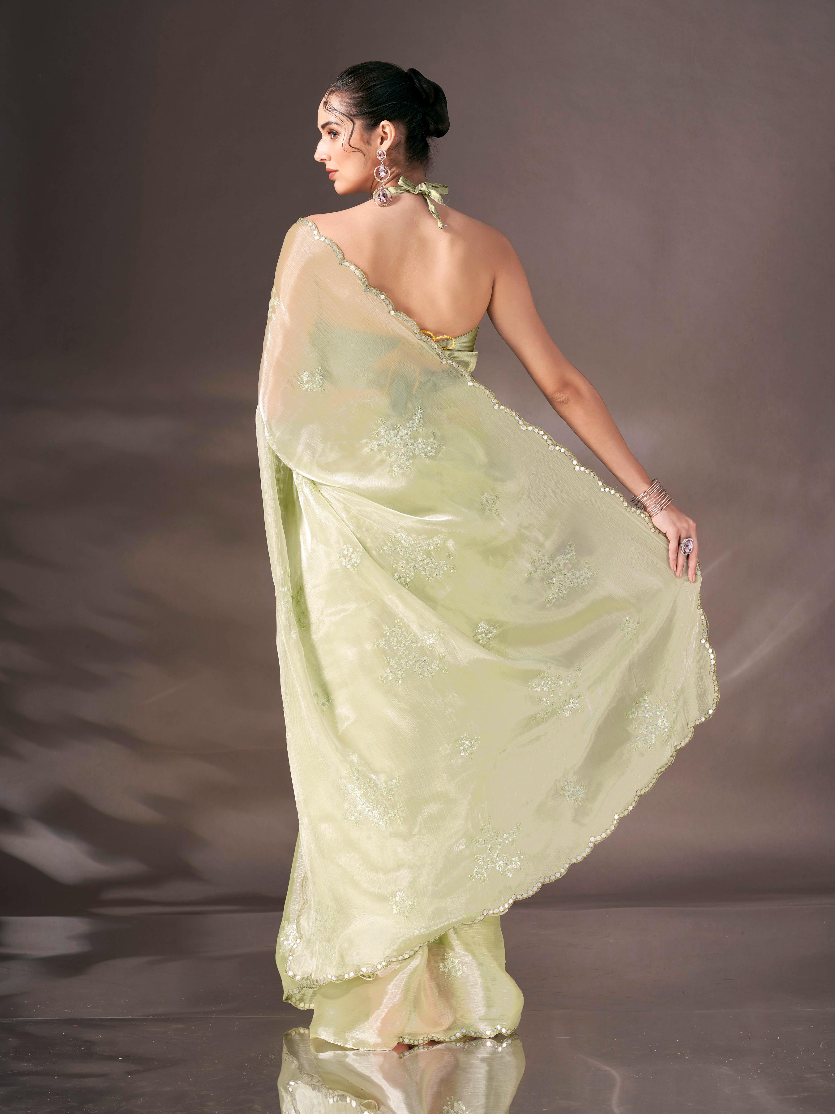 Pista green colored shimmer satin saree with sequence embroidery and scalloped border