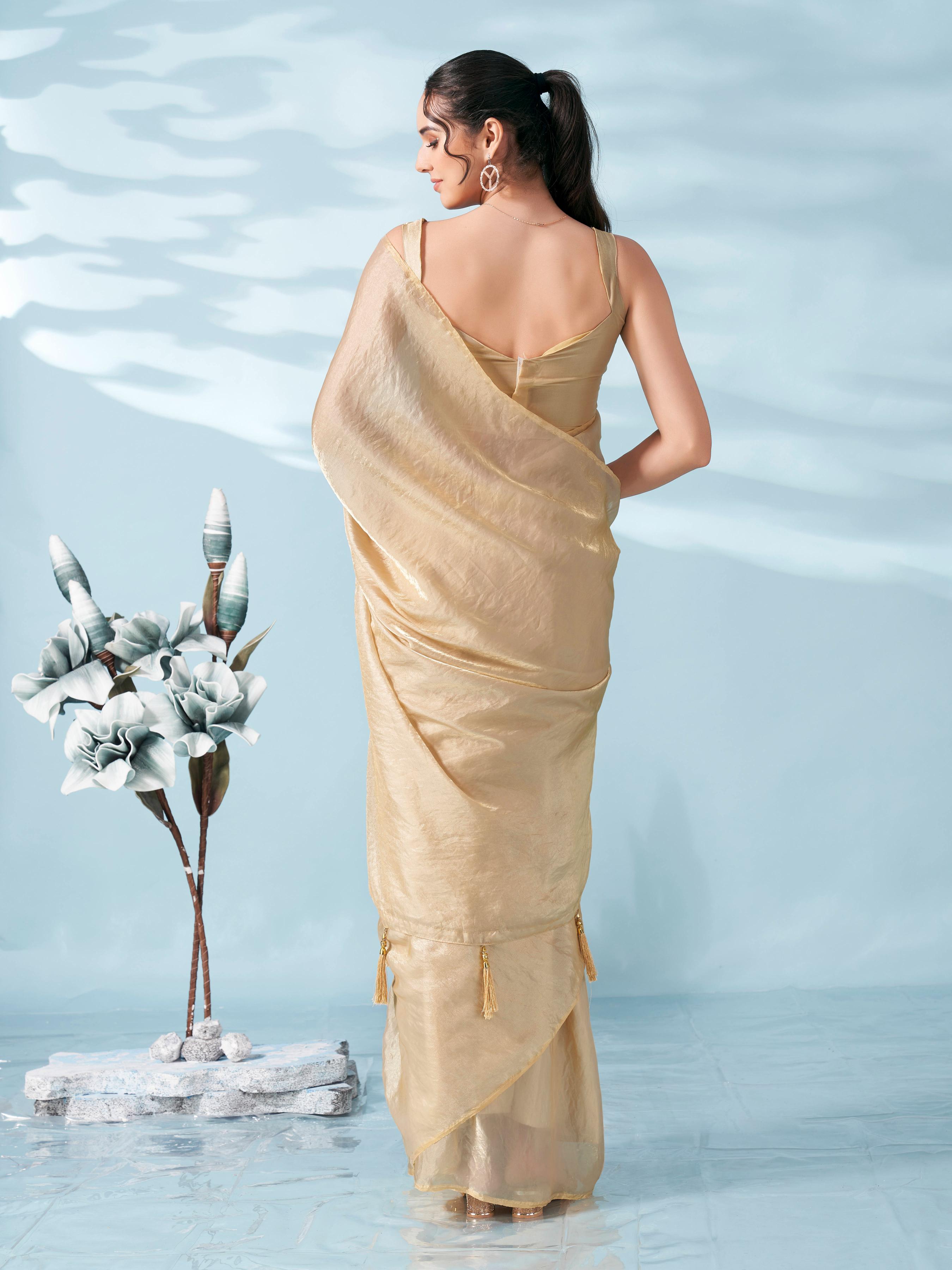 Beige colored satin saree with tassles on pallu