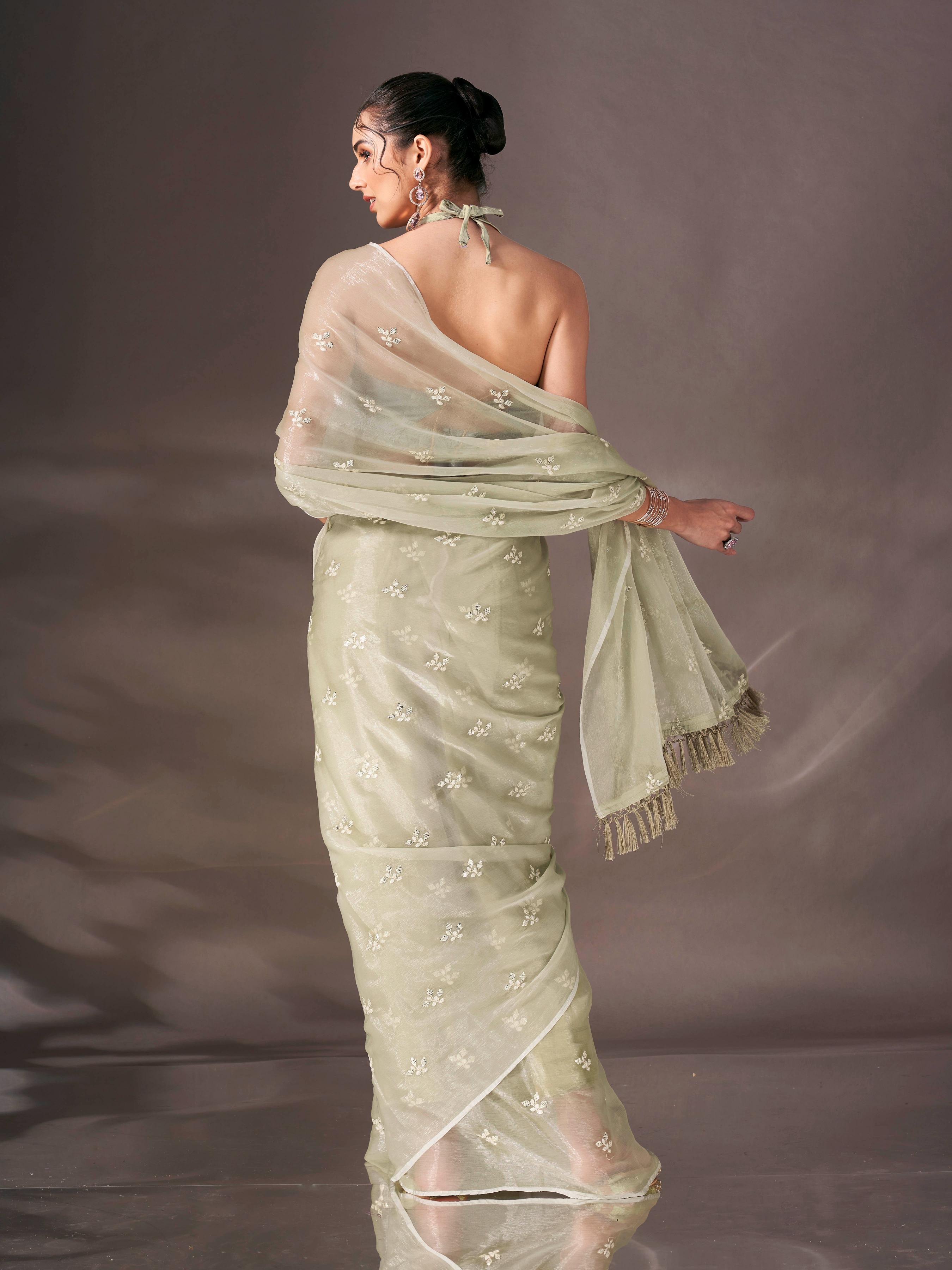 Green colored sequin embroidered shimmer chiffon saree with tassles on pallu