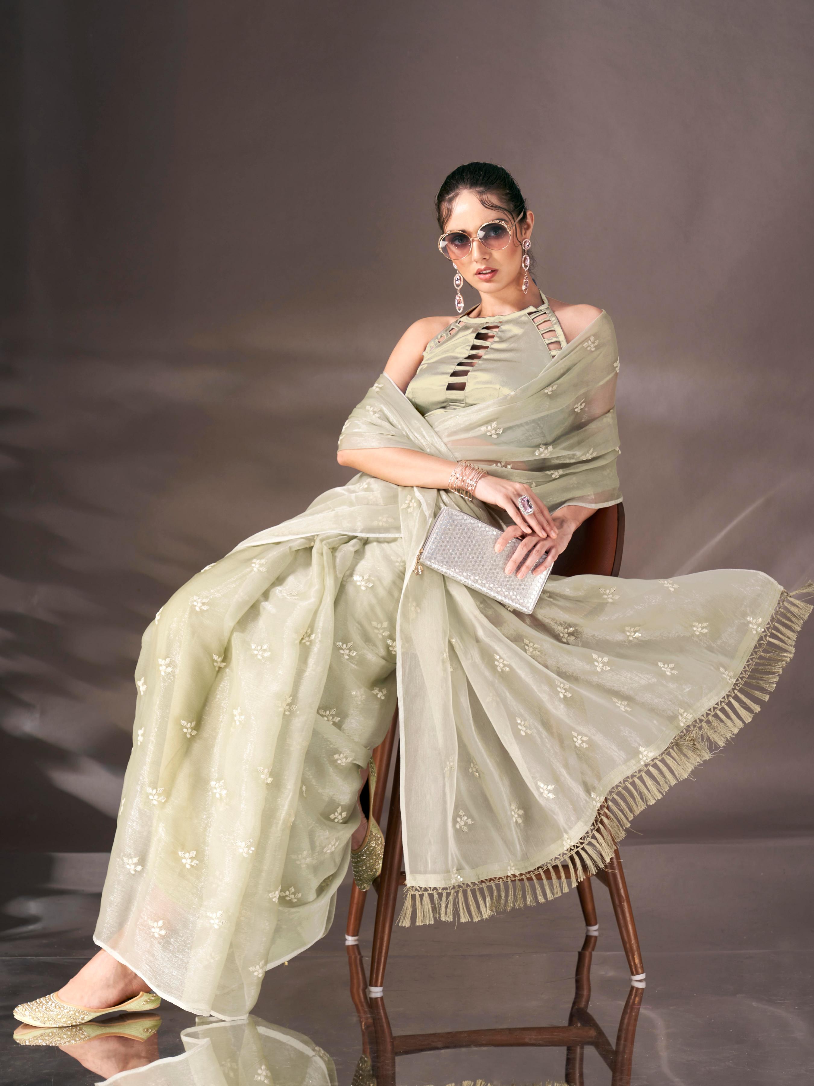 Green colored sequin embroidered shimmer chiffon saree with tassles on pallu