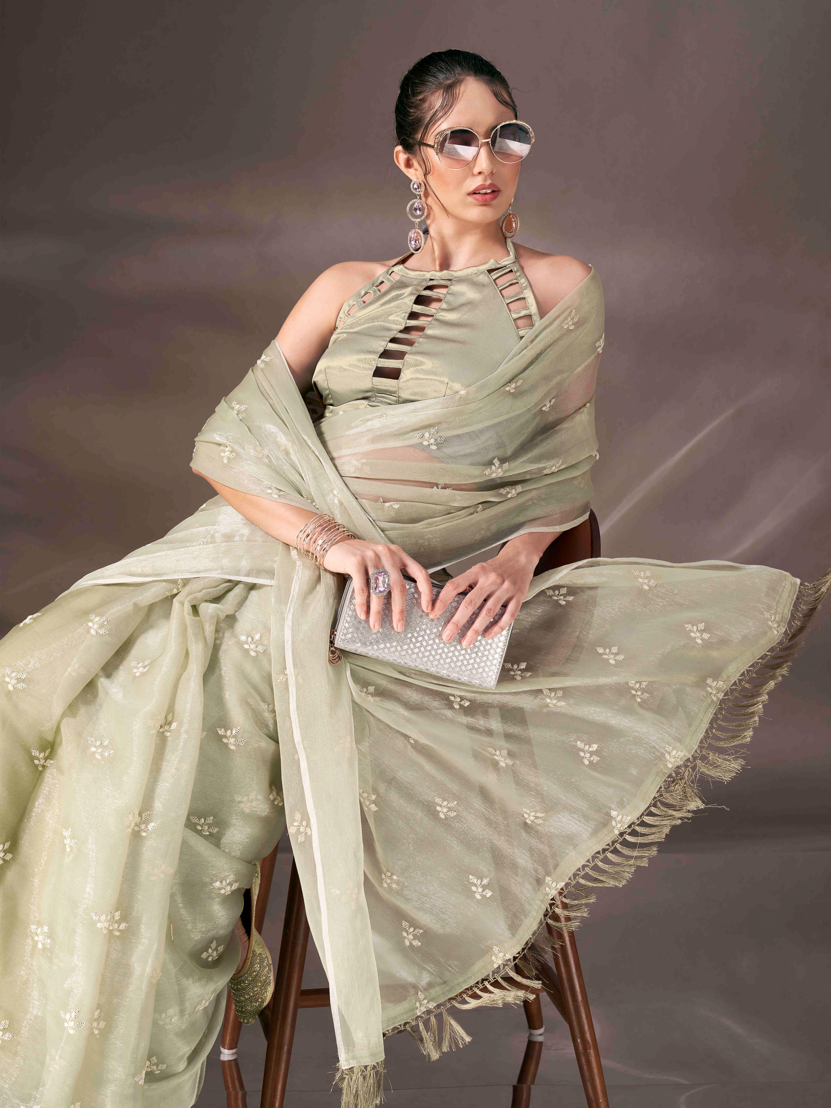 Green colored sequin embroidered shimmer chiffon saree with tassles on pallu