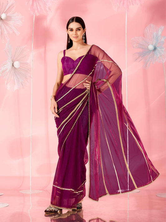 Violet colored designer net saree with faux beads and pearls stitched on pallu