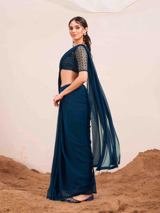 Blue colored designer poly georgette saree with embroidered blouse and a metallic ring on waist to accentuate the pallu