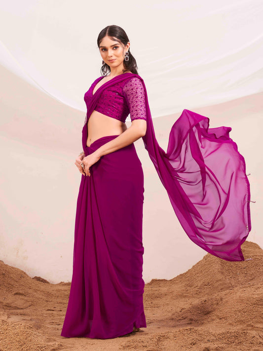 Pink colored designer poly georgette saree with embroidered blouse and a metallic ring on waist to accentuate the pallu