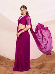 Pink colored designer poly georgette saree with embroidered blouse and a metallic ring on waist to accentuate the pallu