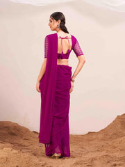 Pink colored designer poly georgette saree with embroidered blouse and a metallic ring on waist to accentuate the pallu