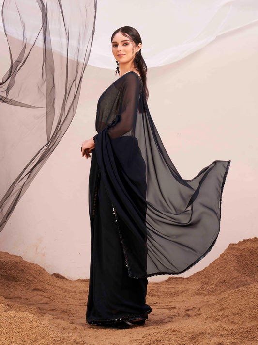 Black colored poly georgette saree with embroidered blouse and belt